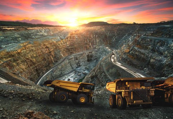 Open-pit mine with haul trucks at sunrise